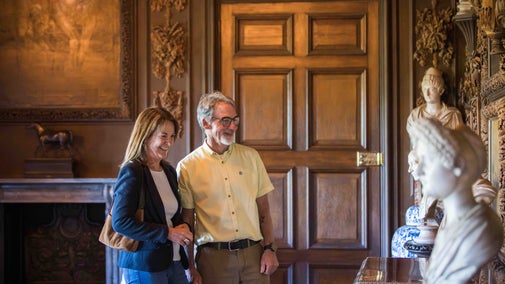 Visitors exploring the Carved Room in Petworth House